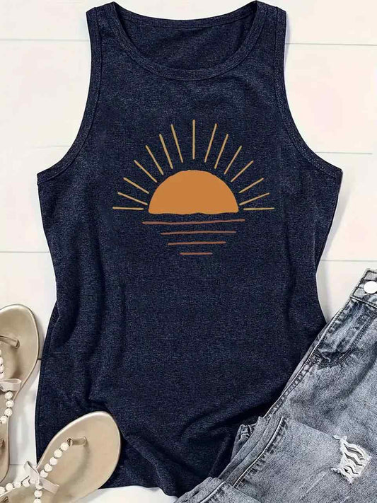 Navy tank top with sunset graphic on a white surface with denim and sandals.