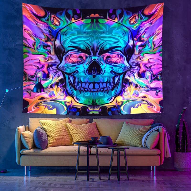 Colorful skull tapestry on a wall above a sofa with decorative pillows.