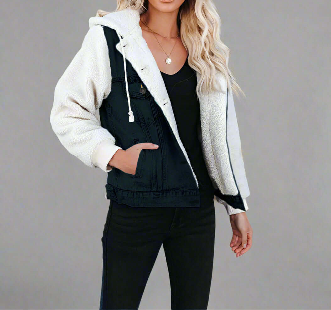 A woman wearing black pants and a denim, sherpa-lined hooded jacket with her hand in the pocket