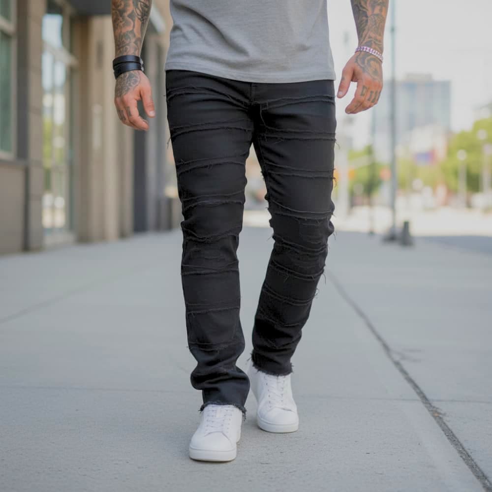 Person wearing black jeans and white sneakers on a city street.