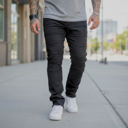 Person wearing black jeans and white sneakers on a city street.