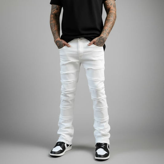 Person wearing white distressed jeans and black shoes on a gray background