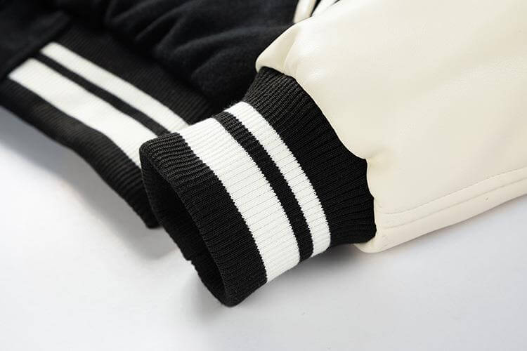 Close-up of black and white striped sleeves on a jacket against a light background