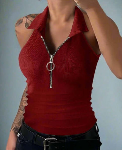 Red sleeveless top with a zipper detail worn by a person against a gray background