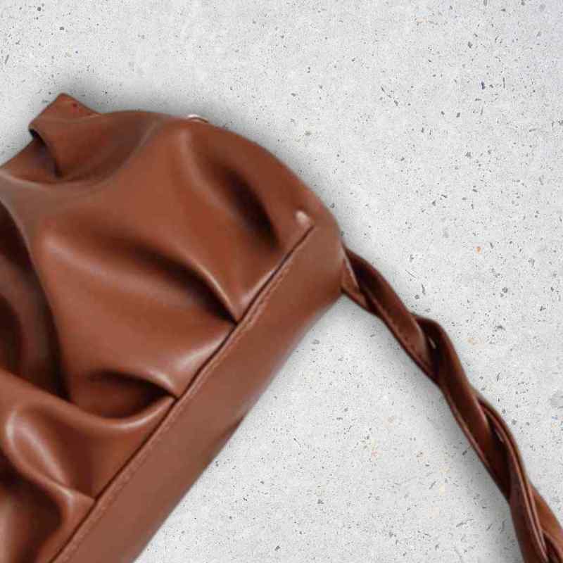 Brown leather bag on a light gray surface