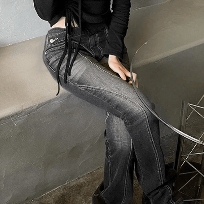A woman wearing black jeans and black shirt sitting on a bench by a glass table