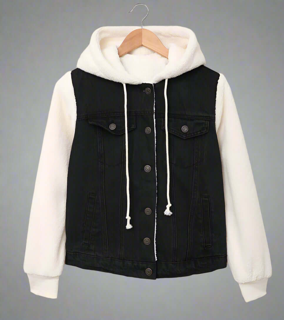 Black denim jacket with white hoodie on a hanger against a beige background