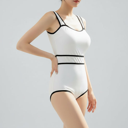 A woman wearing a white one-piece swimsuit with contrasting black straps and trim.