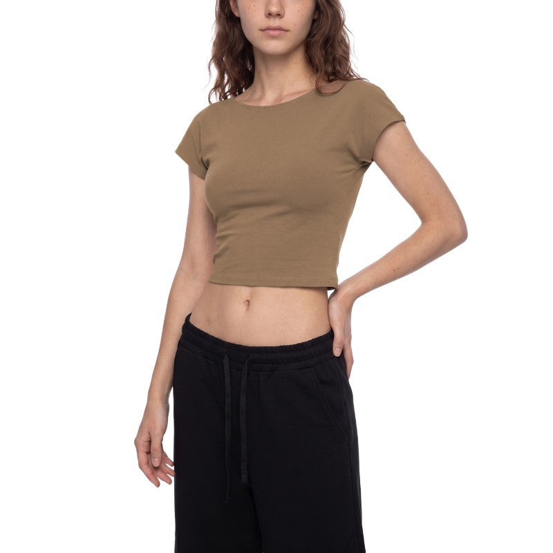 A woman modeling a cropped short-sleeve t-shirt in a muted taupe-brown color, paired with black sweatpants, against a plain white background.