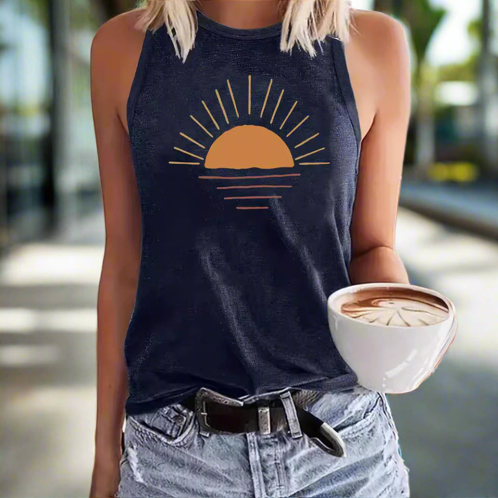 Person wearing a navy tank top with a sun graphic, holding a cup of coffee in an outdoor setting.