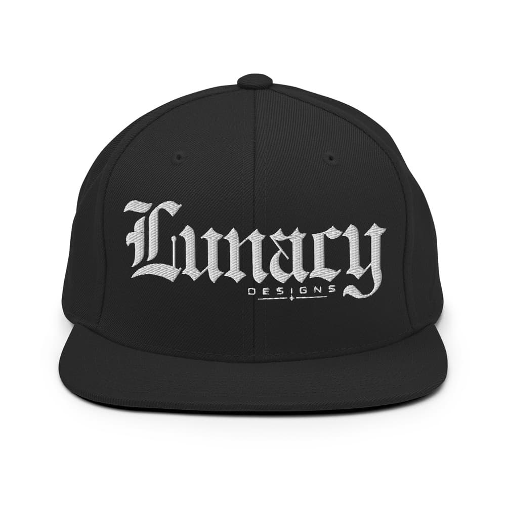 A black flat-brim snapback cap featuring the brand name 'Lunacy DESIGNS' embroidered in white Gothic lettering on the front, set against a plain white background.
