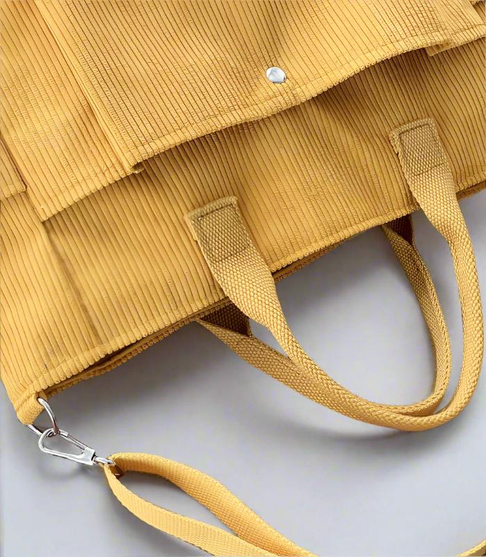 Yellow textured handbag with a strap on a light gray background
