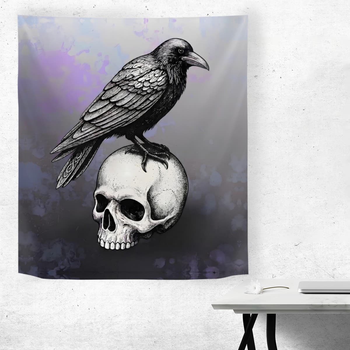 A wall tapestry featuring a detailed black and white illustration of a raven perched on a human skull, displayed on a textured white wall above a small white table.